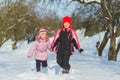 Joyful children playing in snow. Two happy girls having fun outside winter day Royalty Free Stock Photo