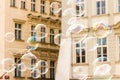 Joyful colorful background lots of transparent soap bubbles background of a facade of a European house lots of airy light bullets Royalty Free Stock Photo