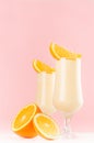 Joyful colorful milk oranges dessert with juicy slices on modern elegant pink color background, vertical.