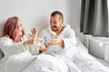 Joyful couple finding out results of a pregnancy test at home lying on bed Royalty Free Stock Photo