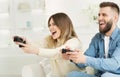 Joyful couple playing online video games by joysticks