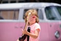 Joyful cute child improvising. Stylish little boy kid wearing a summer pink shirt, funny sunglasses having fun in city Royalty Free Stock Photo