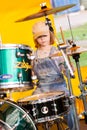 Joyful and cute red hair girl plays the drums