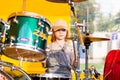 Joyful and cute red hair girl plays the drums