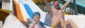 Joyful dad and daughter go down slide in water park Royalty Free Stock Photo