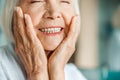 Joyful elderly lady touching her face and smiling Royalty Free Stock Photo