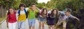 Joyful elementary school boys and girls posing in kids clothes on joint summer child walk in park Royalty Free Stock Photo