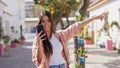 Joyful ethnic woman using smartphone while walking