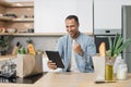 Joyful excited arabian man chef cooking, rejoices to found a favorite recipe on digital tablet