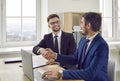 Joyful excited business male partners shake hands after successful office negotiations. Royalty Free Stock Photo