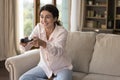 Joyful excited young Latin gamer woman playing virtual video games Royalty Free Stock Photo