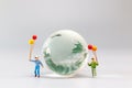 A joyful family with a balloon encircling a crystal globe and the conncept of World Earth Day