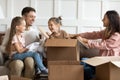 Joyful family couple having fun with children in new apartment. Royalty Free Stock Photo