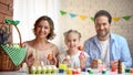 Joyful family with Easter eggs looking at camera, traditional activity, holiday