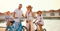 Joyful family riding bicycles along wooden promenade Royalty Free Stock Photo