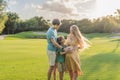 Joyful family time as a pregnant woman, her husband, and son share quality moments outdoors, embracing the beauty of Royalty Free Stock Photo