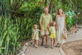 A joyful family, two girls, dad, and a pregnant mom, bask in tropical resort, celebrating a radiant pregnancy amidst