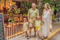 A joyful family, two girls, dad, and a pregnant mom, bask in tropical resort, celebrating a radiant pregnancy amidst