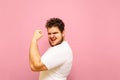 Joyful fat man showing biceps and looking into camera with smile on face isolated on pink background. Portrait of a big boy Royalty Free Stock Photo