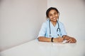 Joyful female doctor sitting at the table in clinic Royalty Free Stock Photo