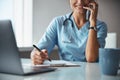 Joyful female doctor talking on cellphone and writing on clipboard Royalty Free Stock Photo