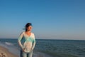 Joyful female traveler walks along the sea coast Royalty Free Stock Photo