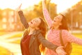 Joyful friends joking raising arms at sunset