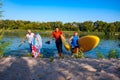 Joyful friends with SUP boards in their hands run out of the water Royalty Free Stock Photo