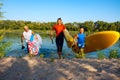 Joyful friends with SUP boards in their hands run out of the water Royalty Free Stock Photo