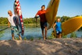 Joyful friends with SUP boards in their hands run out of the water Royalty Free Stock Photo