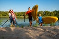Joyful friends with SUP boards in their hands run out of the water Royalty Free Stock Photo
