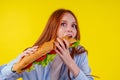 Joyful funny redhaired ginger girl with wild eyes suffering from anarexia with greedy ,eating large sandwic in studio Royalty Free Stock Photo