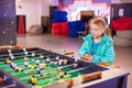 Joyful and gambling girl plays table football
