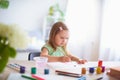Joyful girl child draws gouache in different colors on a white sheet of paper Royalty Free Stock Photo