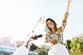 Joyful girl with dark curly hair having fun in sunny morning sitting on scooter, closing eyes. Attractive young woman in Royalty Free Stock Photo