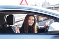 Joyful girl driving a training car with a drivers license card in her hands Royalty Free Stock Photo