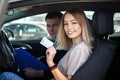 Joyful girl driving a training car with a drivers license card in her hands Royalty Free Stock Photo