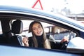 Joyful girl driving a training car with a drivers license card in her hands Royalty Free Stock Photo