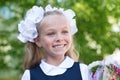 Joyful girl first grader with flowers