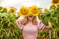A joyful girl plays in a field with sunflowers. Sunflower products. Playful mood
