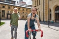 Joyful girl ride bicycle before blurred boyfriend Royalty Free Stock Photo