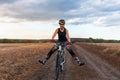 Joyful girl rides a bicycle on a field road Royalty Free Stock Photo