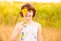 Joyful girl smiling and covering face with sunflower in field Royalty Free Stock Photo