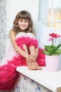 Joyful girl teenager sitting on windowsil in room