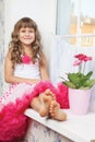 Joyful girl teenager sitting on windowsil in room