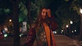 Joyful girl walking dark city park at street lights close up. Model posing alley Royalty Free Stock Photo