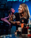 Joyful girl working as tattoo master in small tattoo studio