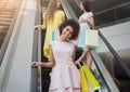 Joyful girls on escalator in shopping mall