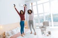 Joyful girls jumping on bed after playing video games Royalty Free Stock Photo