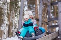 Joyful girls ride a tubing from a hill together. Winter holiday